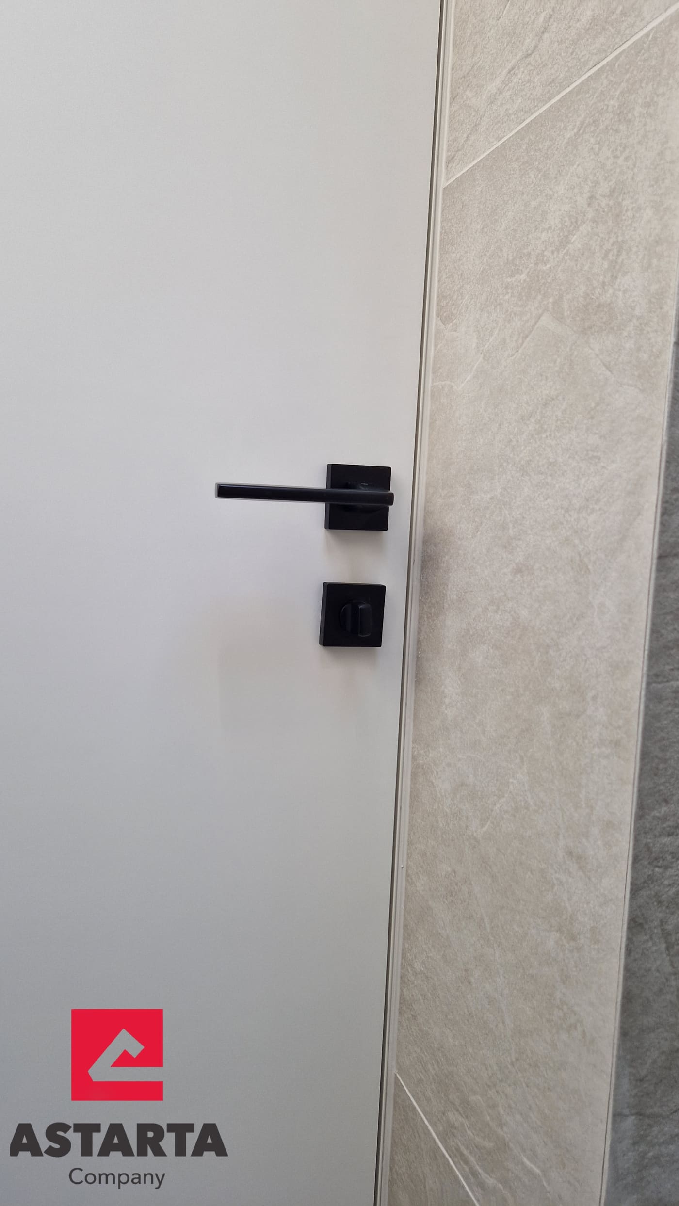 Detalj crne kvake i magnetne brave na filomuro vratima