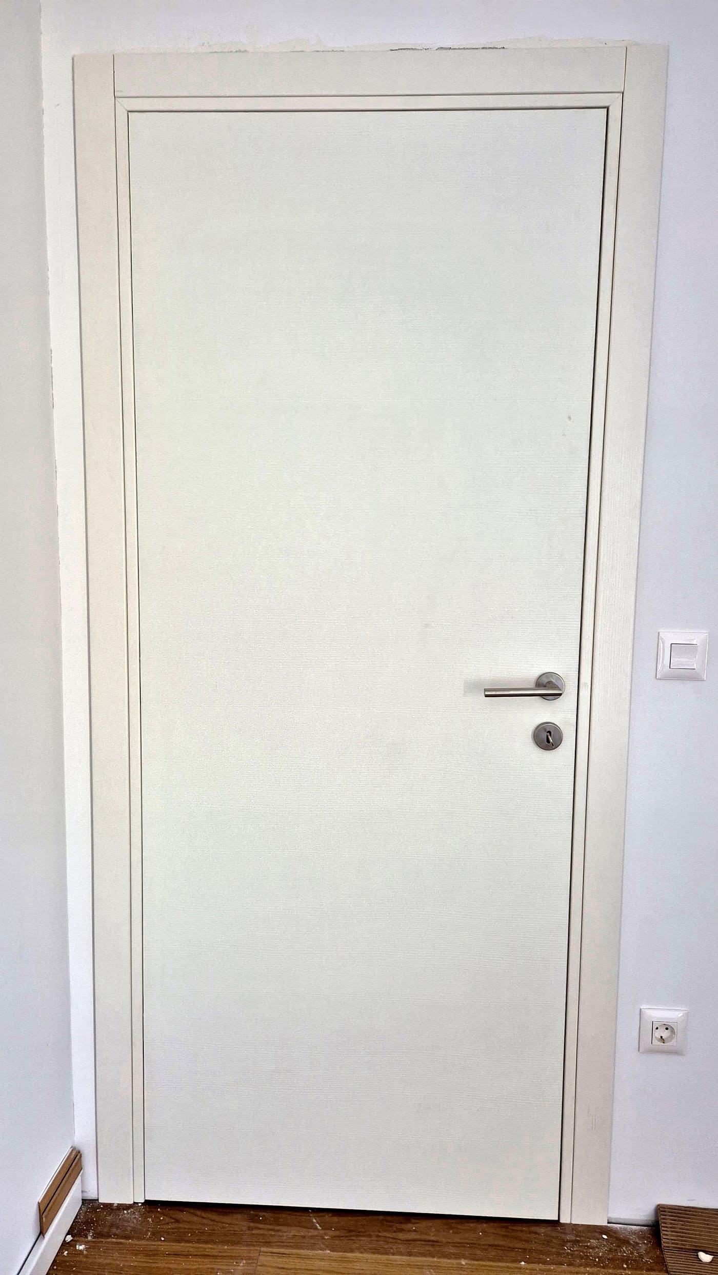 Bijela laminirana vrata s bijelim štokom u hodniku