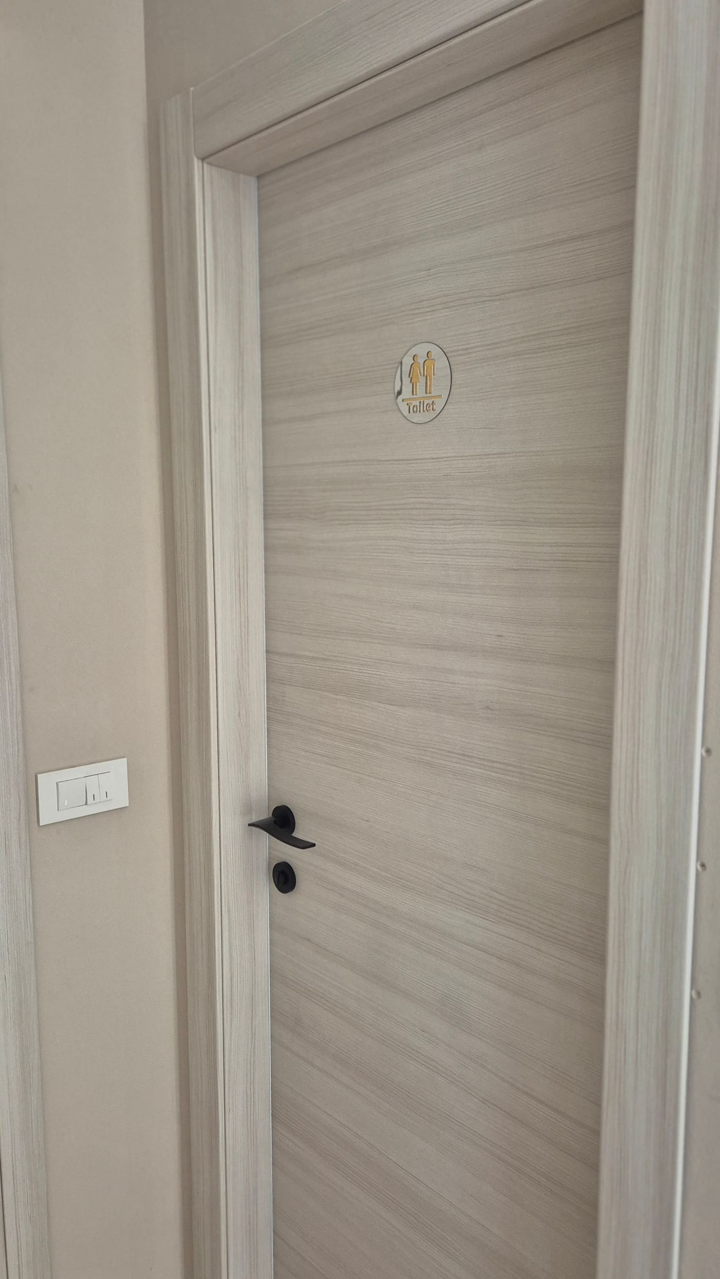 Laminirana vrata u svijetlom dekoru drva s okruglom oznakom na krilu