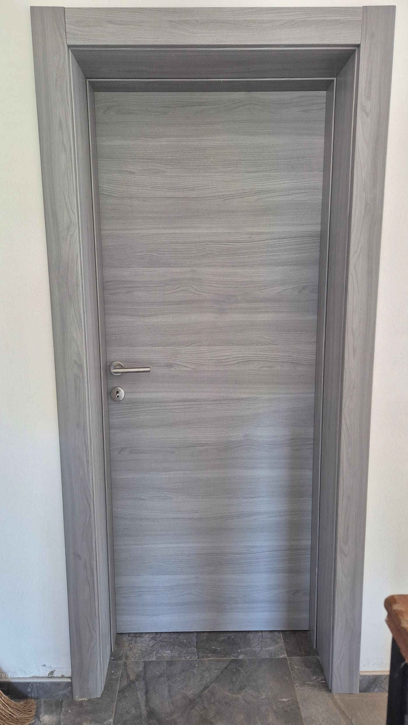 Siva laminirana vrata s vodoravnim crtežom drva