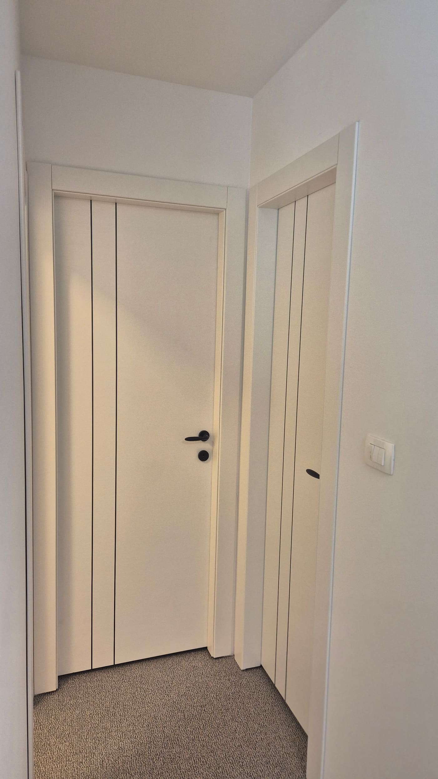 Bijela laminirana vrata s okomitim linijama u hodniku